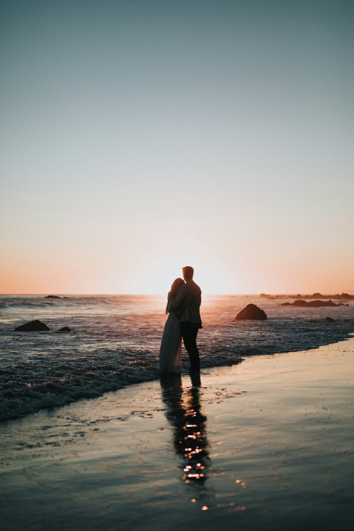 Happy couple on a beach at sunset
